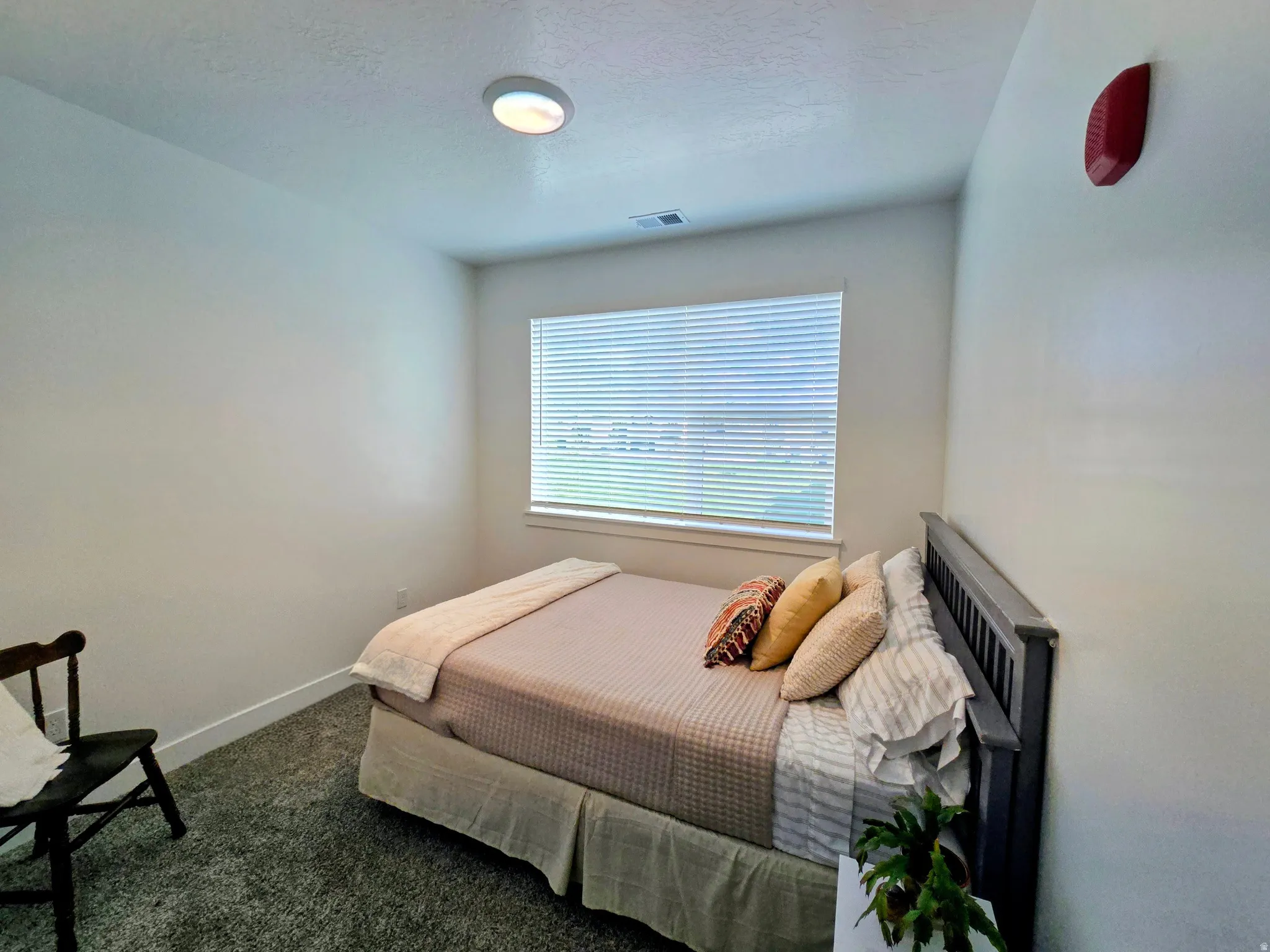 Bedroom featuring dark carpet and a textured ceiling