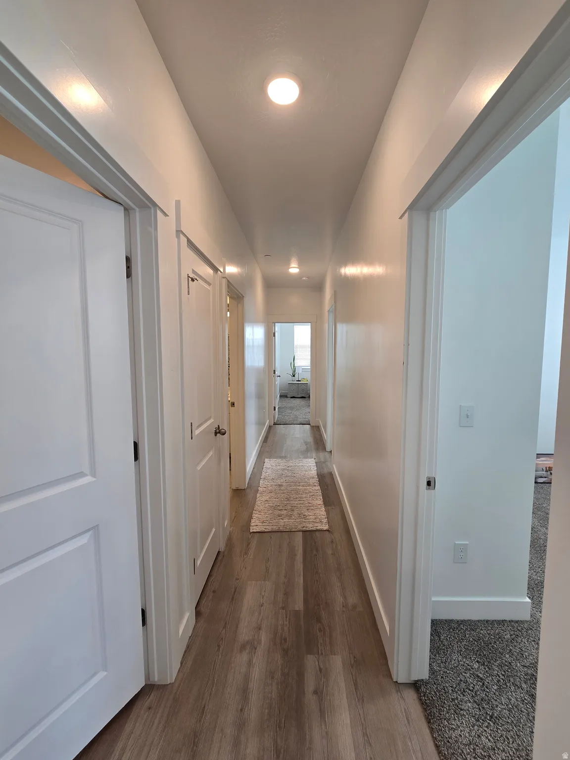 Hallway featuring baseboards and dark wood-type flooring