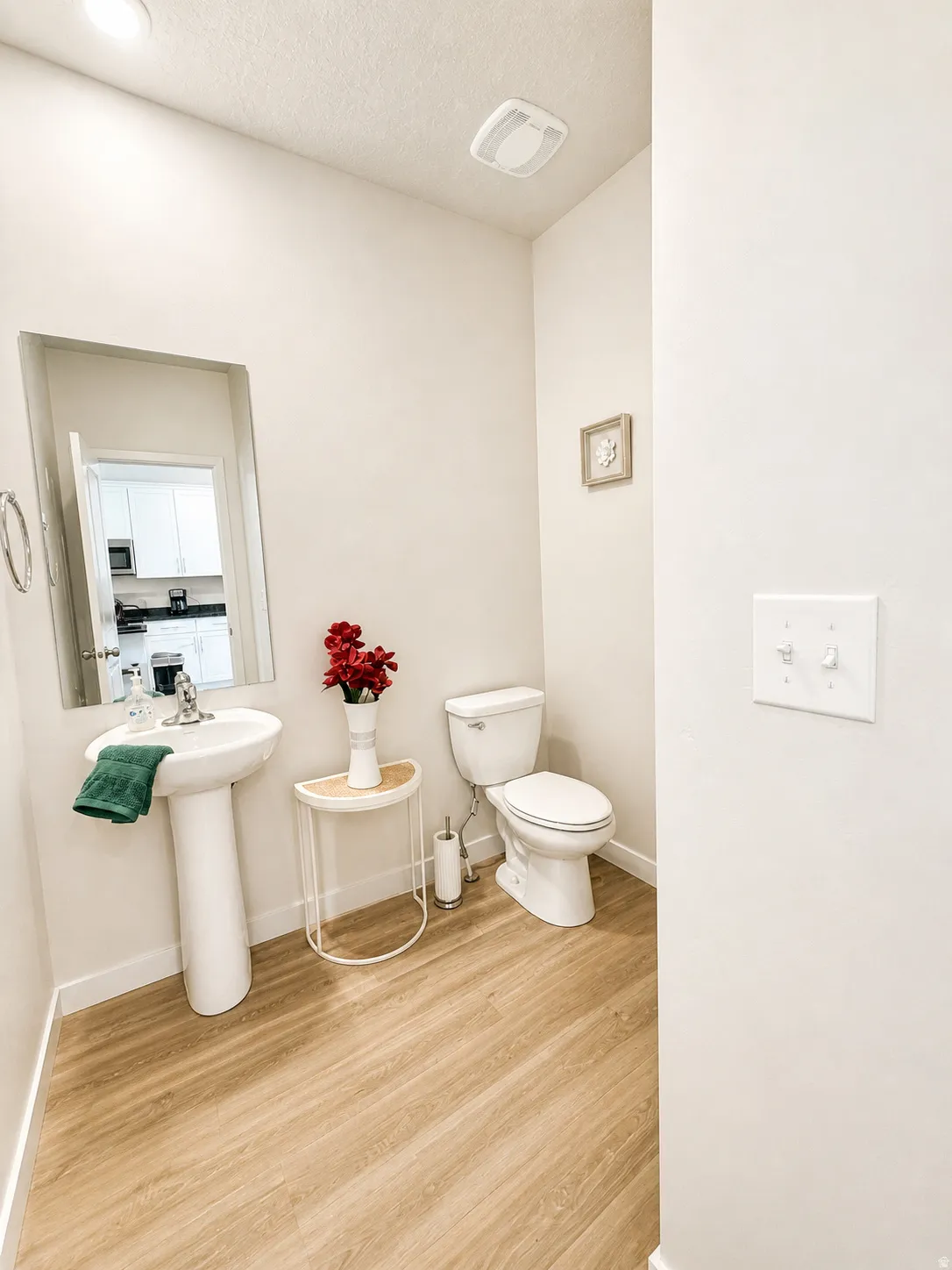 Bathroom with light wood finished floors and a textured ceiling