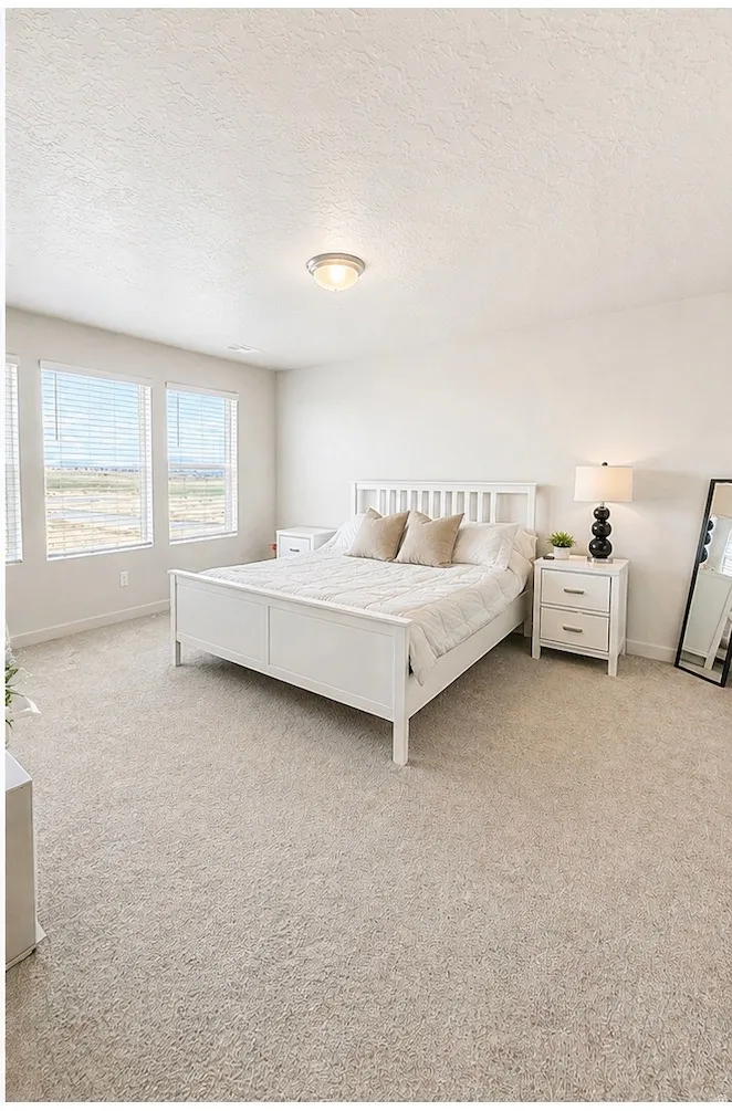 Bedroom with a textured ceiling and light colored carpet