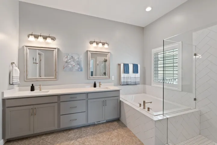 Bathroom featuring double vanity, a bath, tiled shower, light tile patterned flooring, and recessed lighting