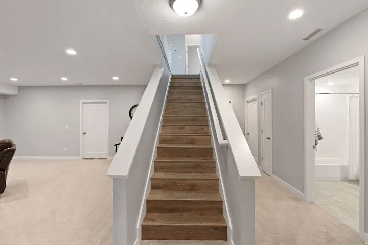 Stairway featuring carpet floors, recessed lighting, and a textured ceiling