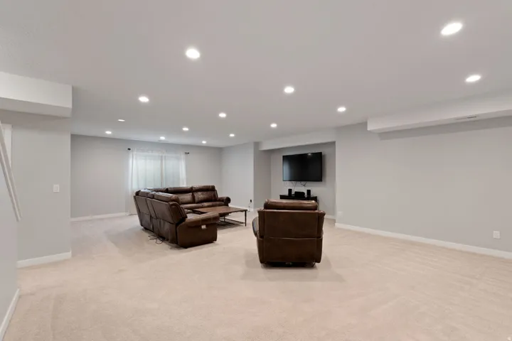 Living room with light colored carpet and recessed lighting