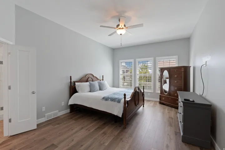 Bedroom with dark wood-style floors and ceiling fan