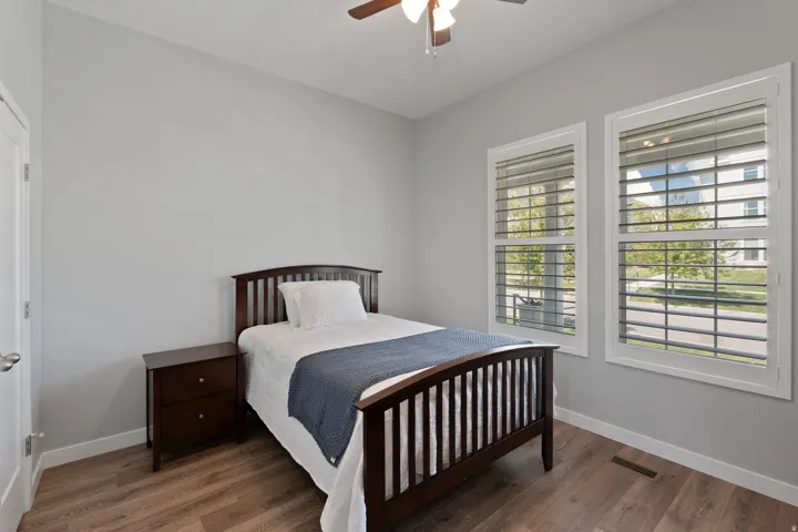 Bedroom with dark wood-style flooring and a ceiling fan