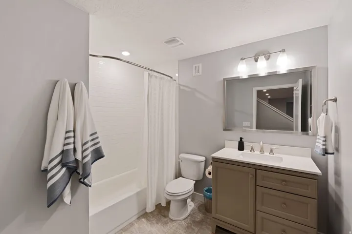 Bathroom featuring vanity, shower / tub combo with curtain, and a textured ceiling