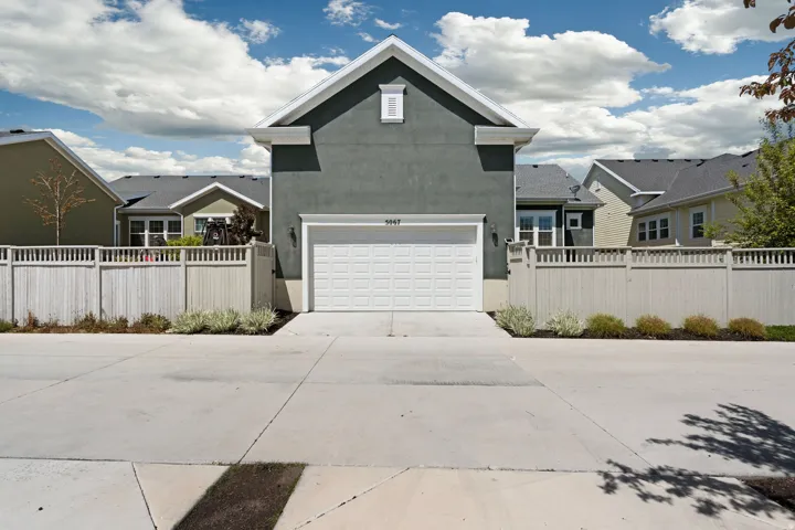 View of front of property featuring stucco siding, concrete driveway, and a garage