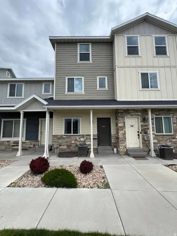 Craftsman house featuring stone siding, board and batten siding, and covered porch