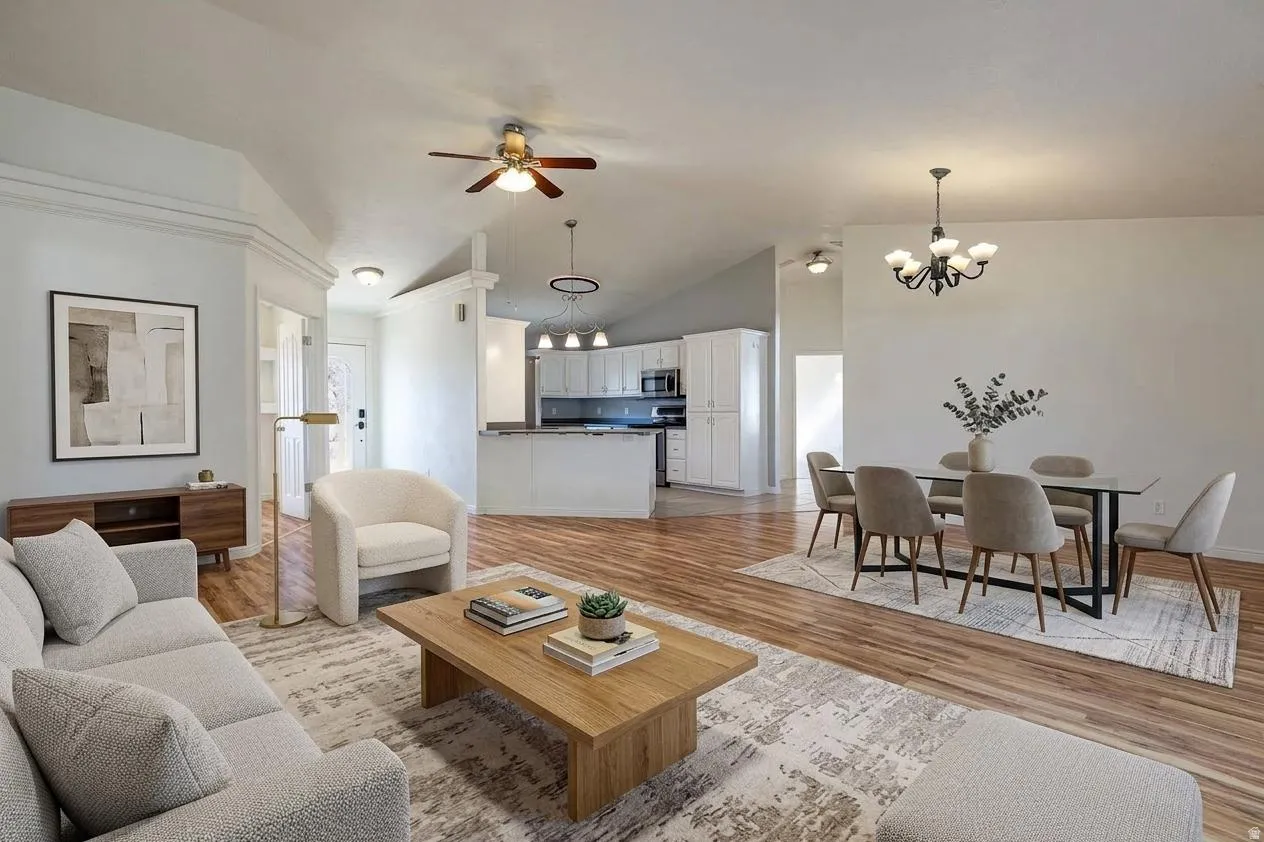 Vaulted ceilings, wood-finish flooring, recessed lighting, and a ceiling fan