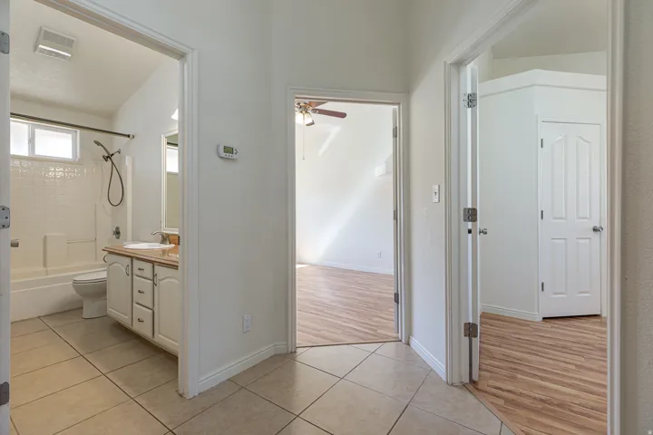 Bathroom with light tile patterned flooring, shower / bath combination, vanity, and a ceiling fan