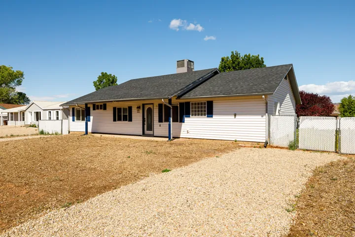 Ranch-style home with a gate, a porch, a chimney, and roof with shingles