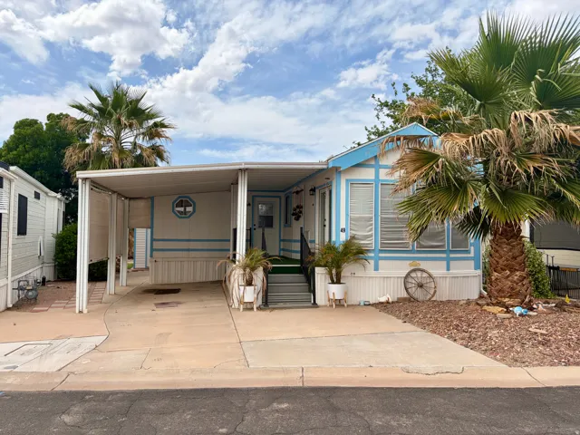 Manufactured / mobile home featuring an attached carport and concrete driveway