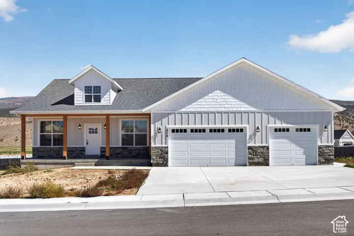 Contemporary ranch-style residence featuring a prominent covered porch with wood columns and a mixed-material exterior finish