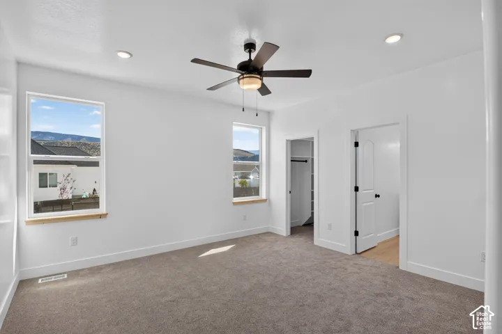 Bright interior featuring white walls, recessed lighting, and a ceiling fan