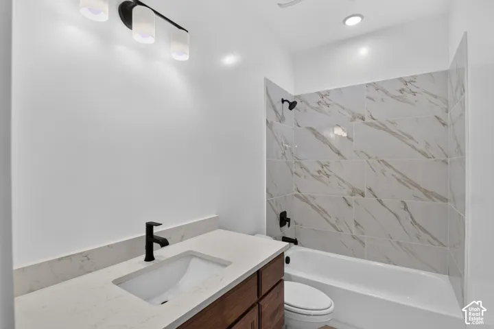 Vanity with a light-toned countertop, wood-finish cabinetry, and matte black fixtures