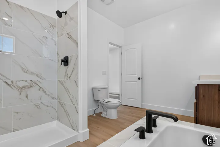 Walk-in shower with marble-look tile surround and matte black fixtures