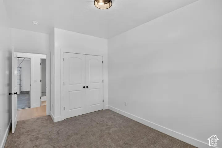 Neutral wall tones, recessed lighting, and carpet flooring