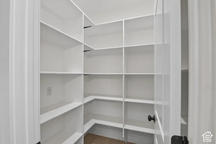 Built-in white shelving system with a corner configuration, providing extensive storage