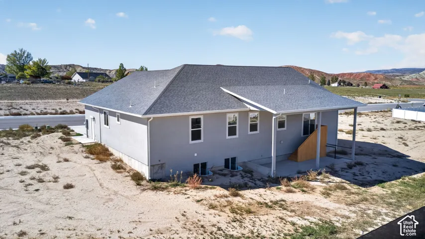 Contemporary stucco exterior with a covered porch and a newly installed shingle roof