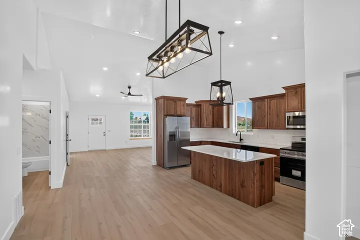 Open-concept living area with vaulted ceilings, wood-finish flooring, and recessed lighting