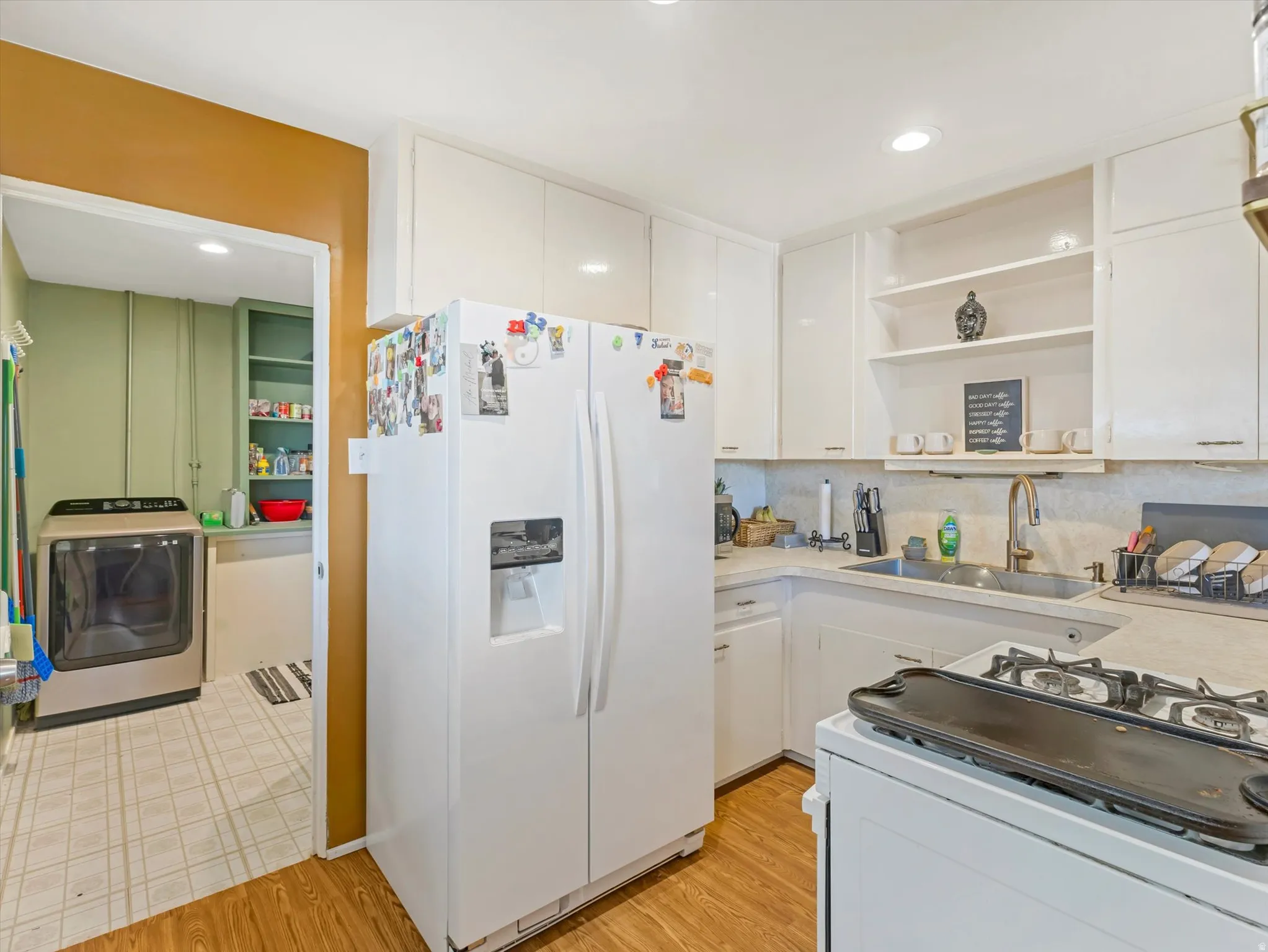 Kitchen with white appliances, open shelves, washer / clothes dryer, light countertops, and recessed lighting