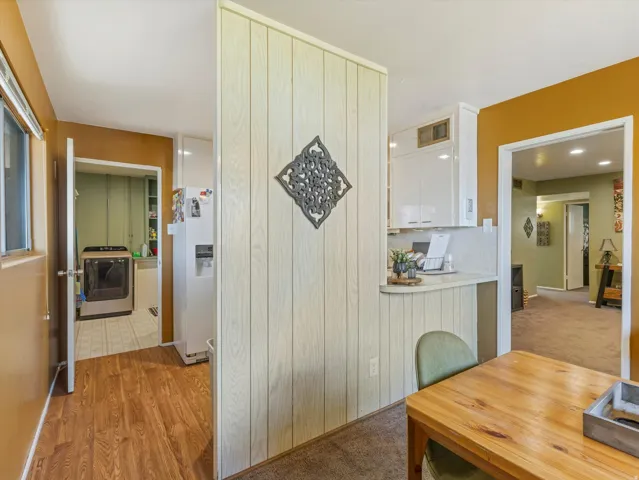 Corridor with washer / clothes dryer and light wood finished floors