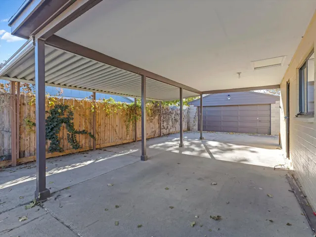Fenced backyard featuring an outbuilding