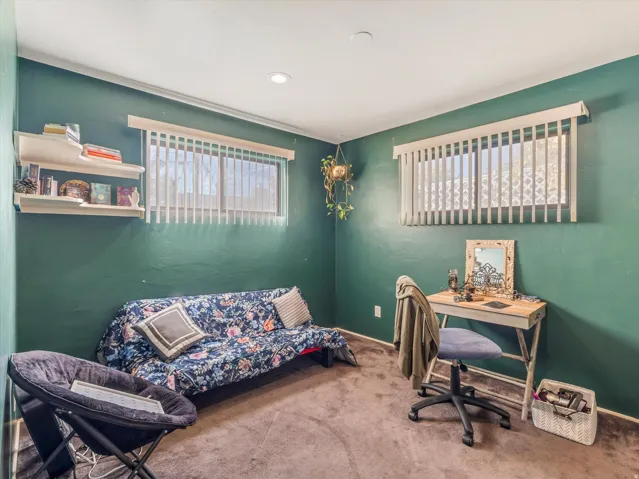 Carpeted home office featuring baseboards