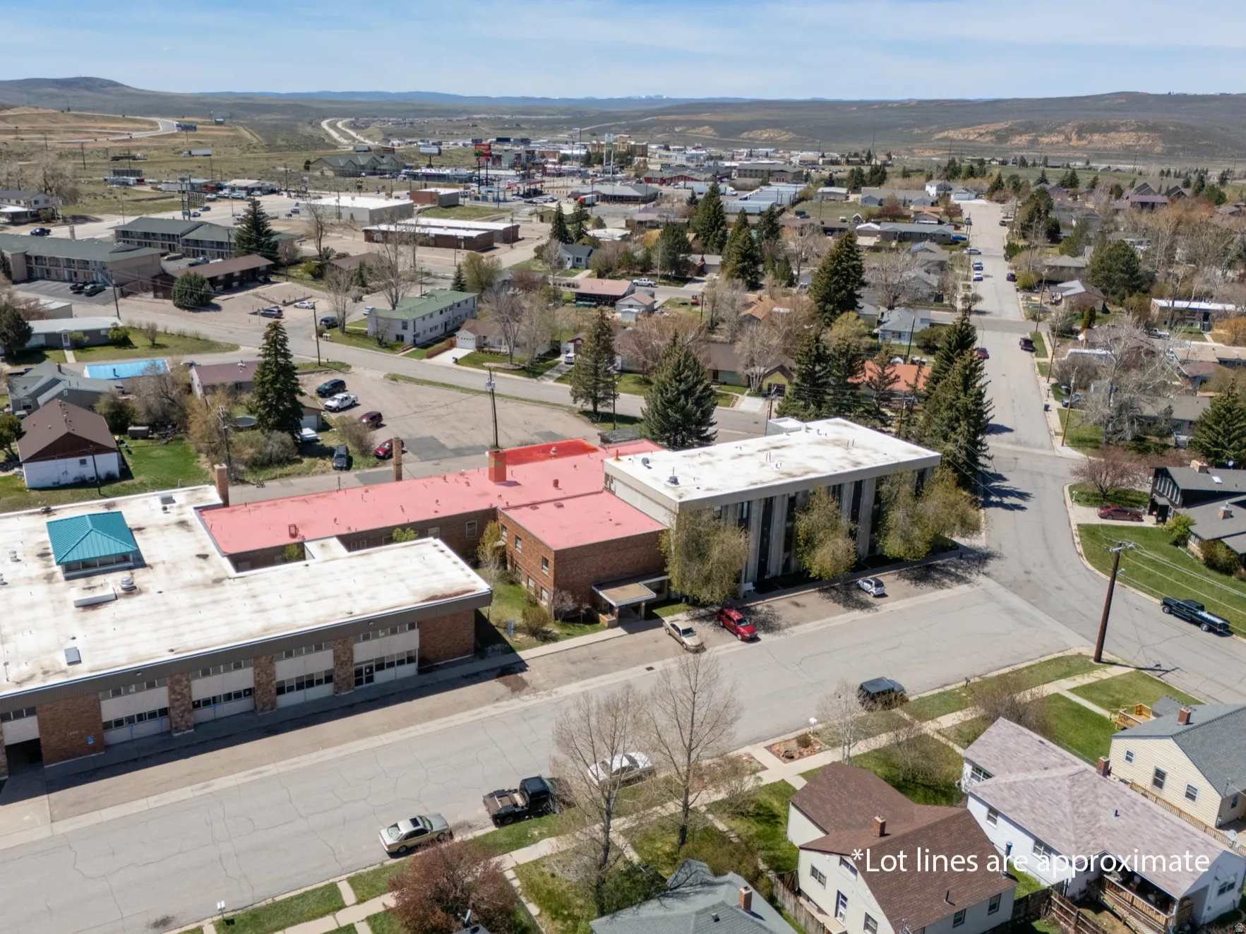 Commercial property featuring multiple buildings with flat roofs, brick facades, and ample paved parking