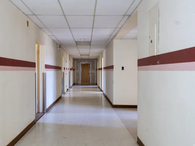Long hallway with light-colored walls featuring a dual-stripe accent