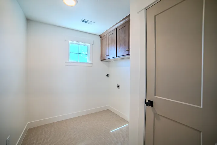 Laundry room with cabinet space, light carpet, and electric dryer hookup