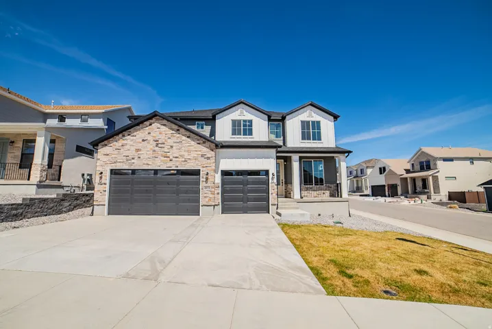 Modern farmhouse featuring covered porch, driveway, board and batten siding, stone siding, and a residential view
