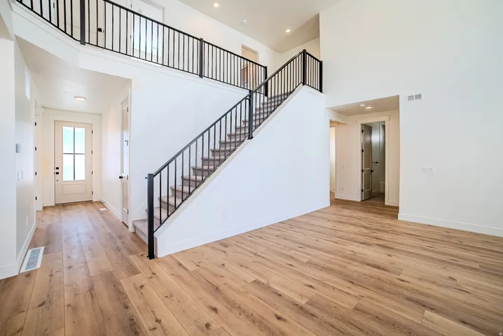 Foyer featuring light wood-style flooring, a high ceiling, and recessed lighting
