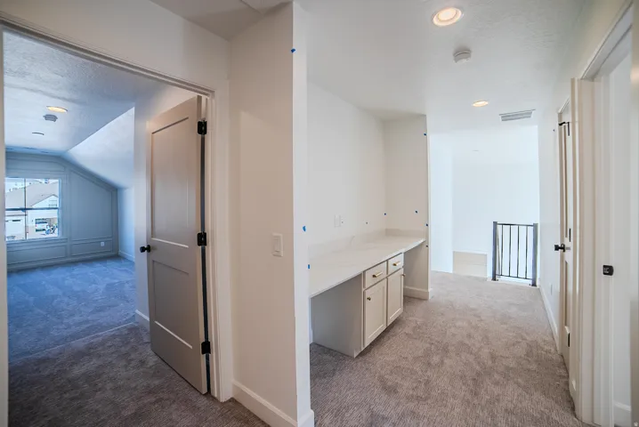 Hallway featuring light colored carpet and recessed lighting