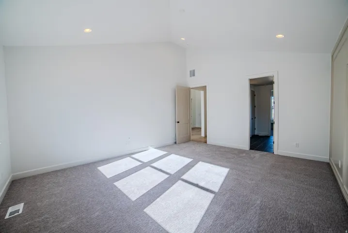Unfurnished bedroom featuring recessed lighting, carpet, and vaulted ceiling