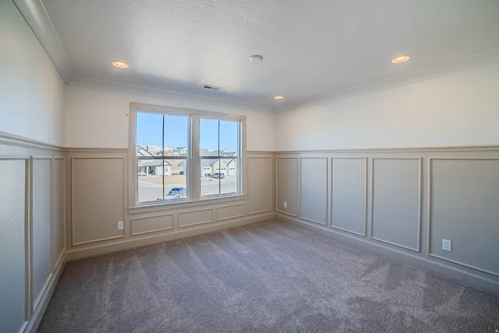 Unfurnished room featuring a decorative wall, a wainscoted wall, carpet floors, and recessed lighting