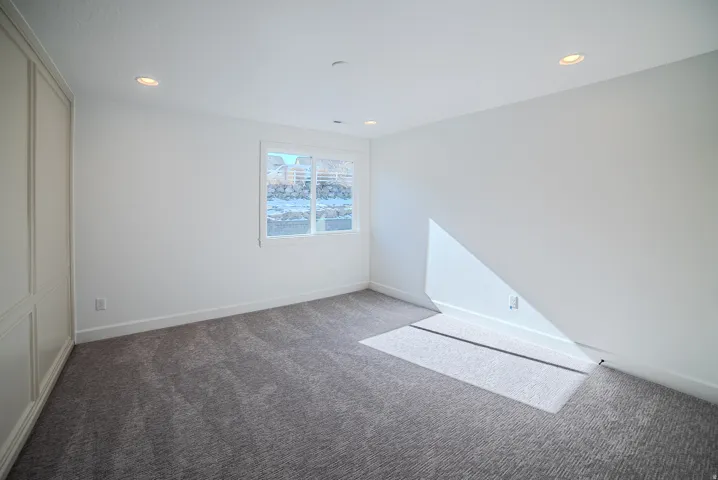 Unfurnished bedroom featuring carpet, a closet, and recessed lighting