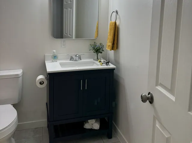 Bathroom featuring a dark wood vanity with a white countertop, undermount sink, and chrome faucet