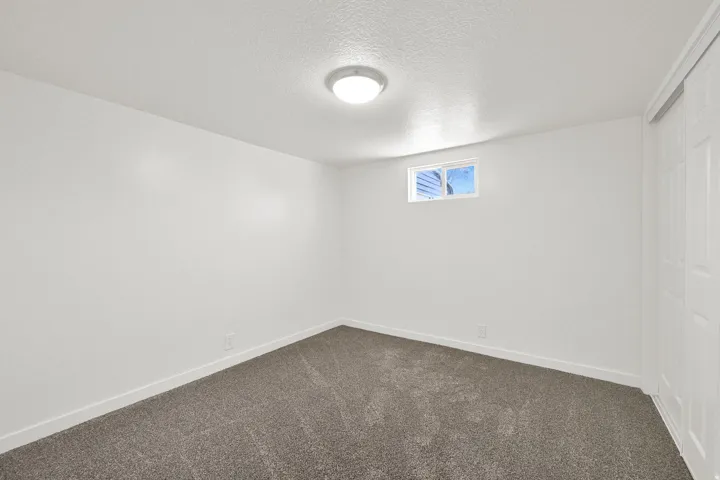 Spare room with a textured ceiling and dark carpet