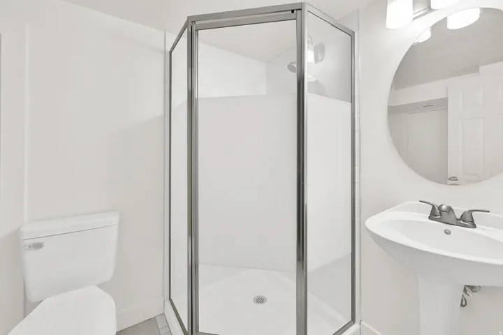 Full bath with toilet and a shower stall
