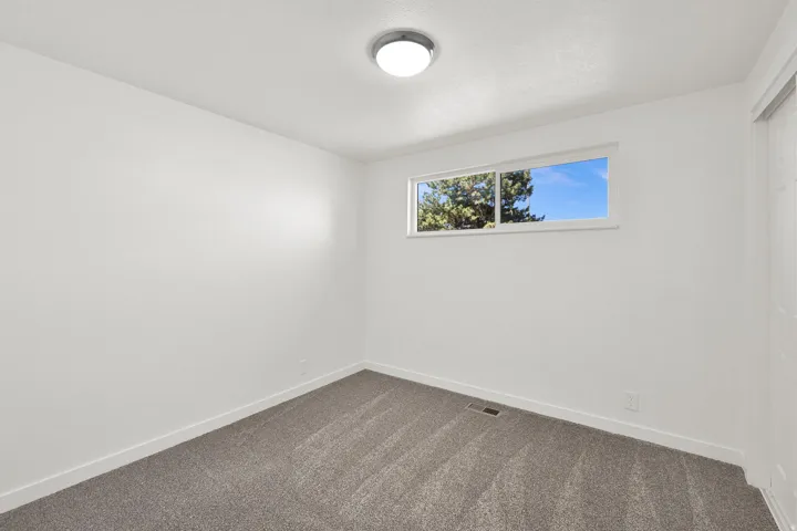 Spare room with baseboards and dark colored carpet