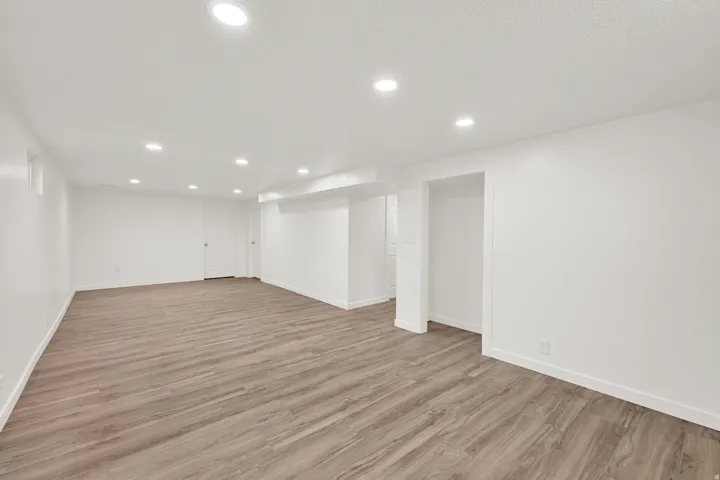 Finished below grade area featuring recessed lighting and light wood-style flooring
