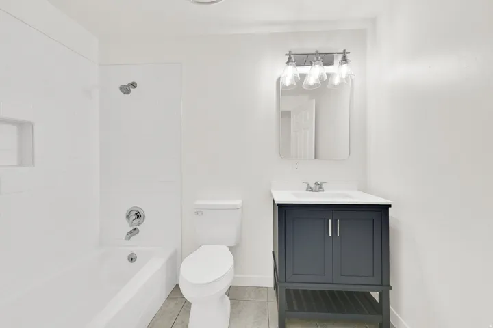 Bathroom featuring vanity, shower / bath combination, and light tile patterned floors