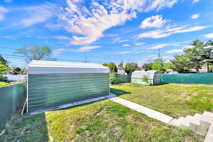 Fenced backyard featuring a shed