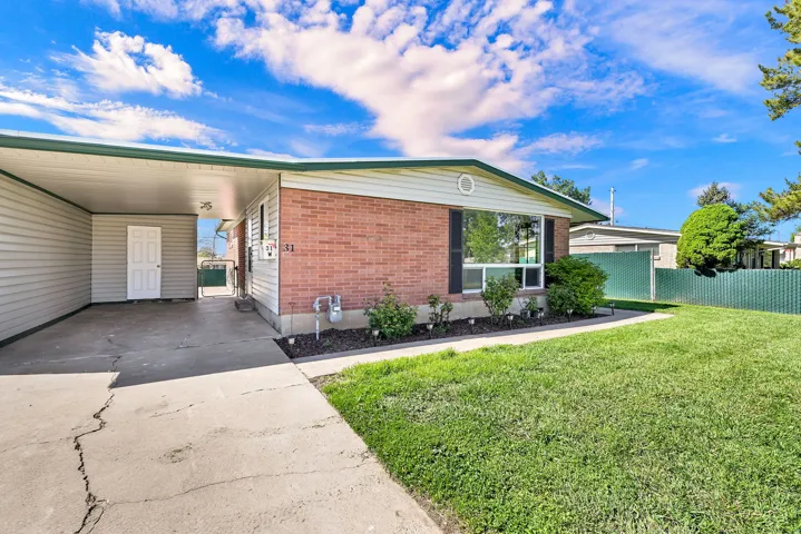 View of front of property with brick siding, concrete driveway, and an attached carport