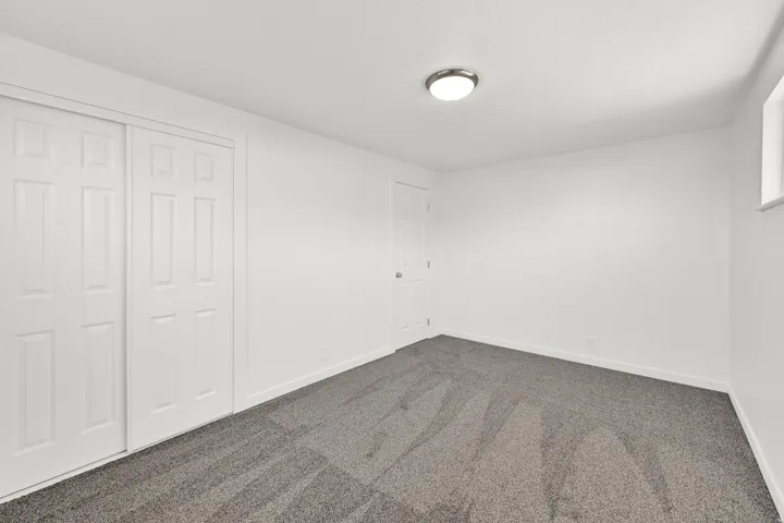 Unfurnished bedroom with dark carpet and a closet