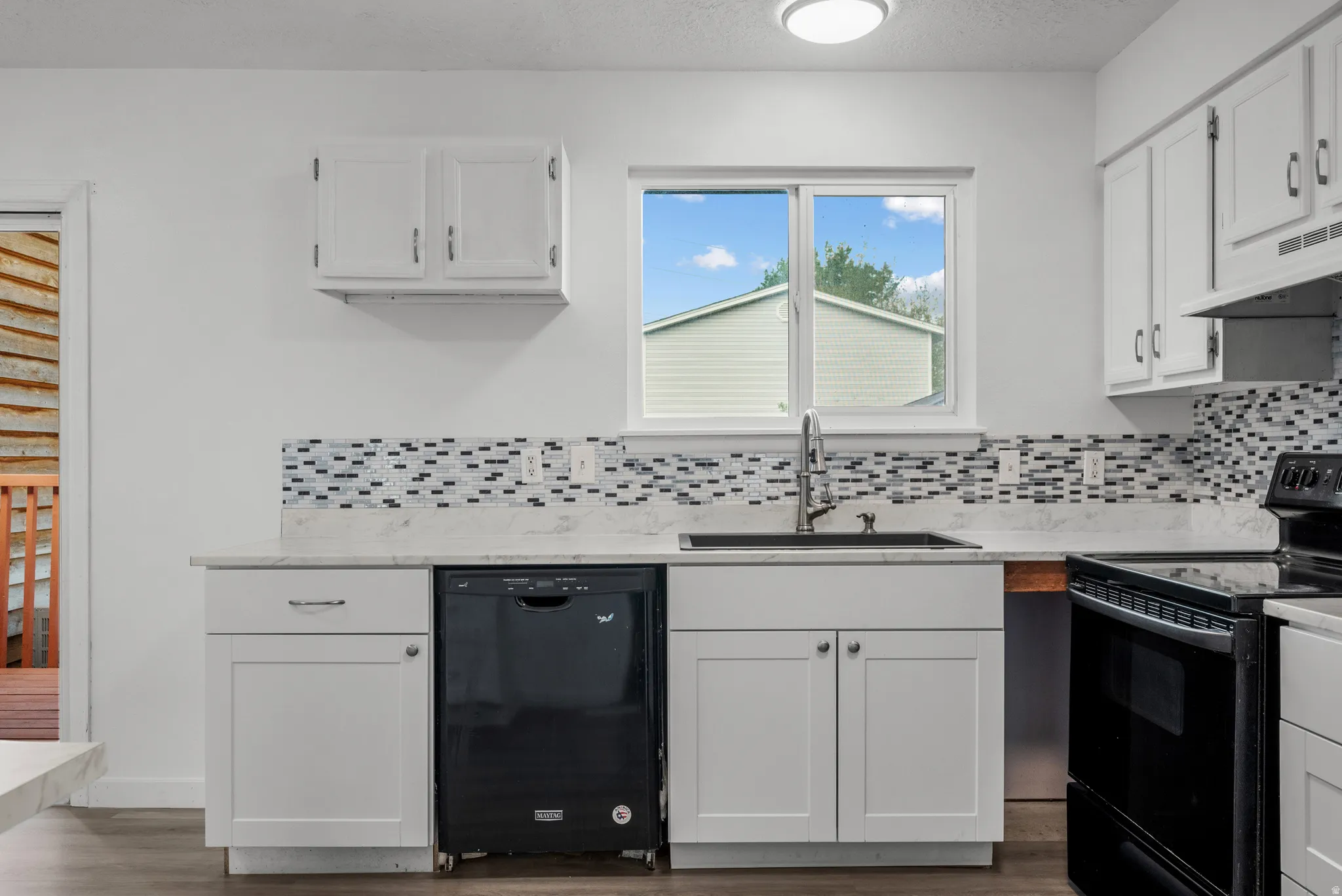 Kitchen featuring white cabinetry, light countertops, and a patterned tile backsplash