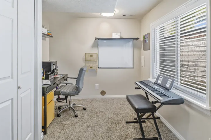 Office with baseboards and light colored carpet