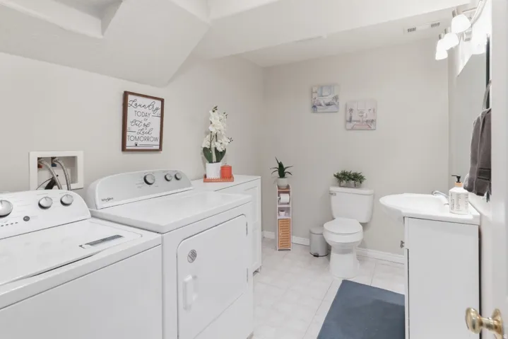 Bathroom featuring vanity, independent washer and dryer, and light flooring