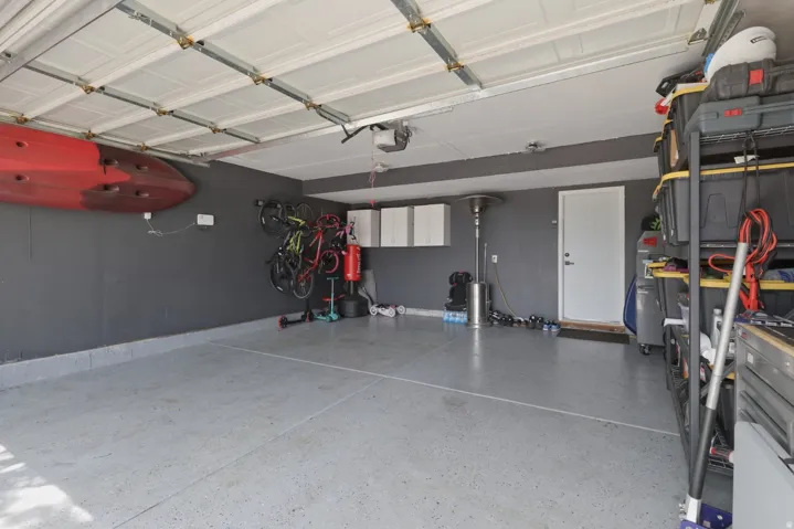 Garage featuring baseboards and a garage door opener